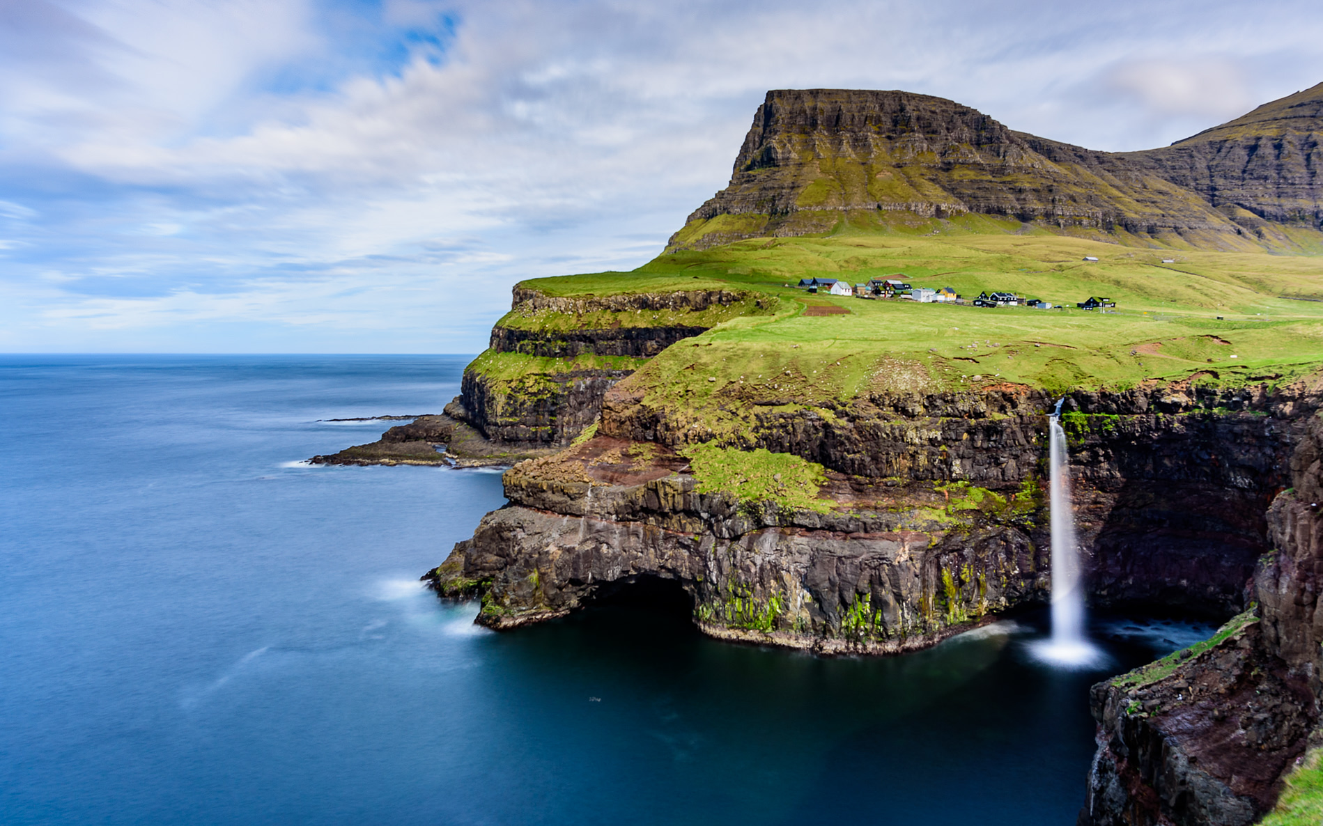 A waterfall dropping from a coastal cliff in the Faroe Islands